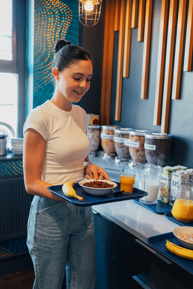 Guest enjoying breakfast at the hostel’s self-service dining area